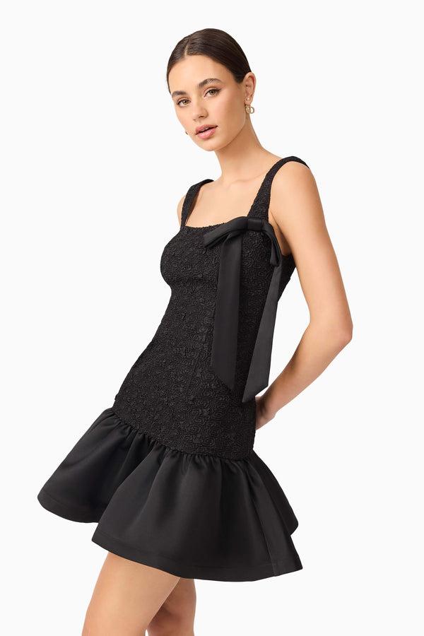Brunette model wearing Dandelion Mini Dress in Black close up shot