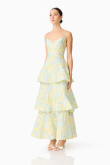 Brunette model wearing the Penelope Tiered Gown in Yellow & Blue Floral side shot 