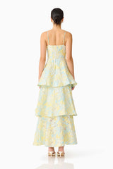 Brunette model wearing the Penelope Tiered Gown in Yellow & Blue Floral back shot 