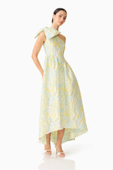 Brunette model wearing the Penelope Asymmetrical Gown in Yellow & Blue Floral posed shot 