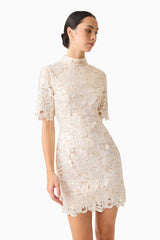 Brunette model wearing the Nicoletta Short Sleeve Mini Dress in Gold close up looking away shot