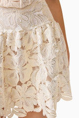 Brunette model wearing the Nicolette Top & Skirt Set in Gold skirt detail shot 