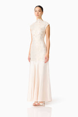 Brunette model wearing the Nicoletta High Neck Gown in Gold side shot