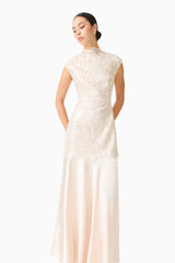 Brunette model wearing the Nicoletta High Neck Gown in Gold posed looking away shot