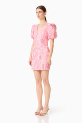 Brunette model wears the Monique Puff Sleeve Mini Dress in Pink, side shot