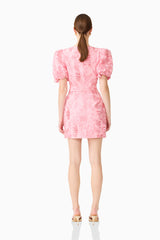 Brunette model wears the Monique Puff Sleeve Mini Dress in Pink, back shot