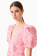 Brunette model wears the Monique Puff Sleeve Mini Dress in Pink, detail shot