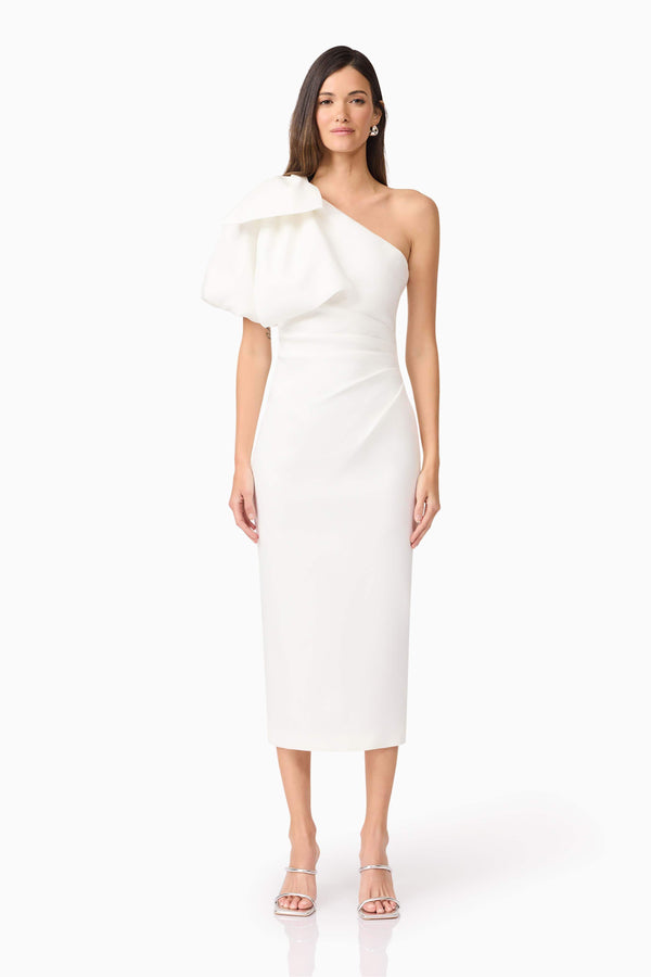 Brunette model wears Elysie Midi Dress in White front view