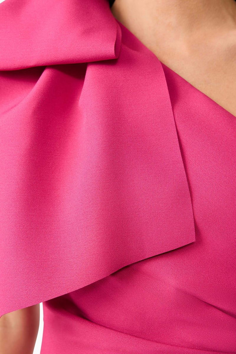 Brunette model wears Elysie Midi Dress in Pink front view detailed close up