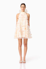 Brunette model wears Livia Trapeze Mini Dress in White front view