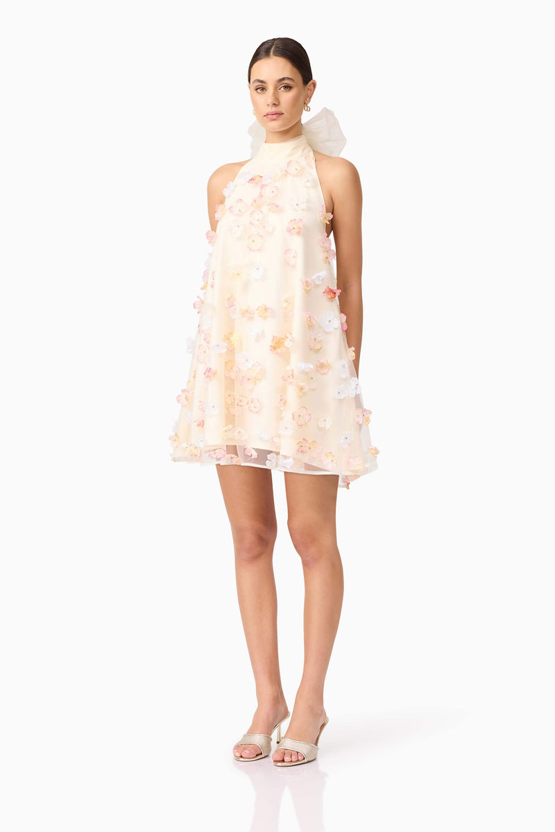 Brunette model wears Livia Trapeze Mini Dress in White side view