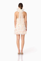 Brunette model wears Livia Trapeze Mini Dress in White back view
