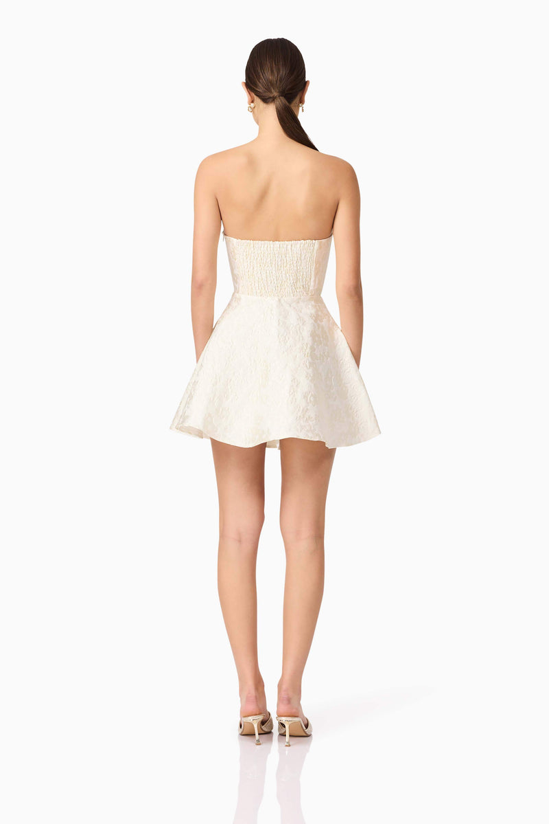 Brunette model wearing Galadirel Strapless Mini Dress in White back shot