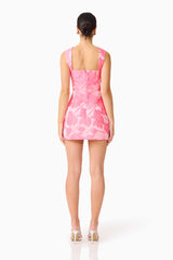 Brunette model wearing the Dionne Tulip Mini Dress in Pink Floral Back shot