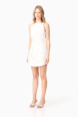 Blonde model wearing Elara Shift Dress in White side shot 