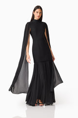 Brunette model wearing the Odelia Cape Sleeve Gown in Black movement shot
