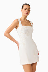 Brunette woman wearing the Odelia Beaded Mini Dress in White, posed with hand on hip