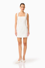 Brunette woman wearing the Odelia Beaded Mini Dress in White, head tilted, front shot