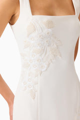 Brunette woman wearing the Odelia Beaded Mini Dress in White, detail shot of the embellished pearl flowers