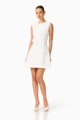 Brunette model wearing the Reina Applique Mini Dress Dress White posed side shot