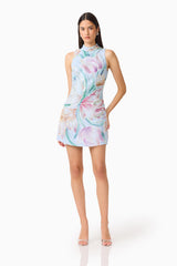 Brunette model wearing the Priselle High Neck Mini Dress in Blue Floral posed side shot
