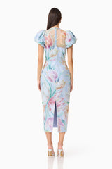 Brunette model wears the Priselle Puff Sleeve Midi Dress in Blue Floral back shot