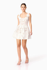 Brunette model wearing Margot Floral Mini Dress in White posed shot