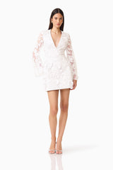 Lorina Flared Sleeve Mini Dress in White  with V-neckline &  sheer long sleeves with 3d floral appliques posed shot 