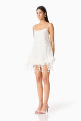 Brunette model wearing the Rina Shift Mini Dress in White side shot.