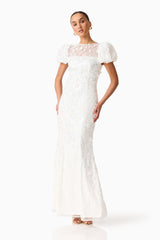 Brunette model wearing the Rina Puff Sleeve Gown in White posed shot