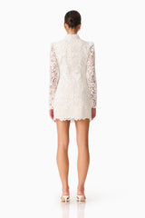 Brunette model wearing the Cora Long Sleeve Mini Dress in White back shot