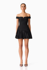 Brunette model wears the Elva Off Shoulder Mini Dress in Black front shot