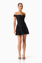 Brunette model wears the Elva Off Shoulder Mini Dress in Black posed shot