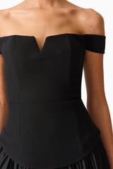 Brunette model wears the Elva Off Shoulder Mini Dress in Black detail shot