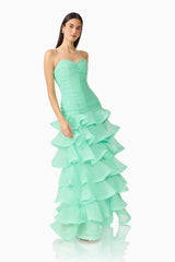 Brunette model wearing the Evelin Tiered Gown in Mint Green posed leaning shot