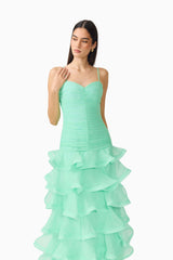 Brunette model wearing the Evelin Tiered Gown in Mint Green close up shot