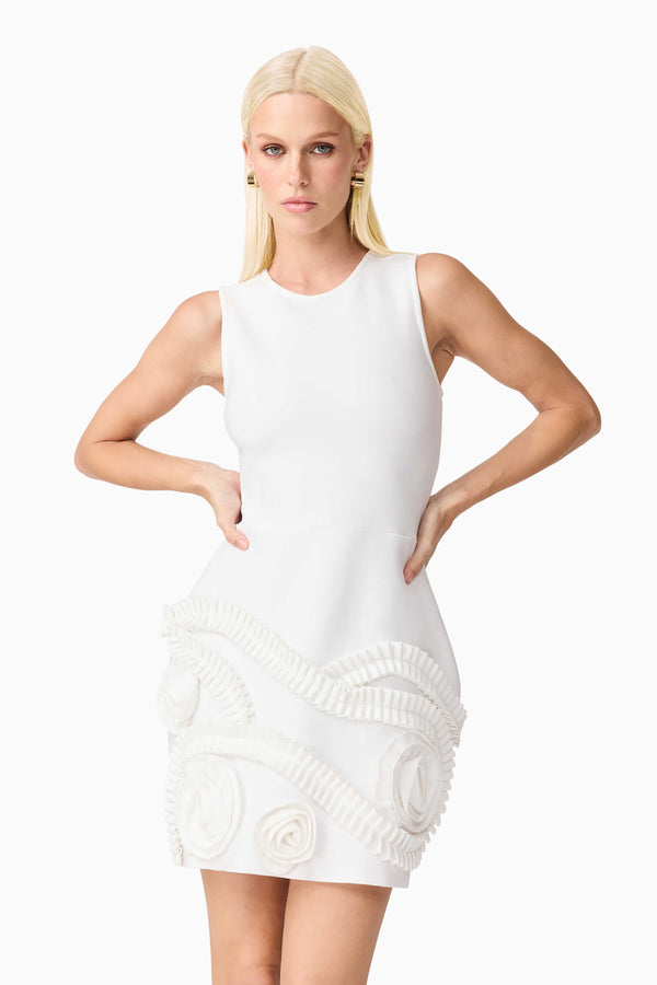 Blonde model wearing the Sonya Tulip Mini Dress in White close up hands on hip shot