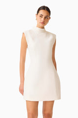 Elysia Lace Mini Dress in White with high collar neckline & tulip silhouette close up looking away shot