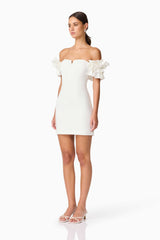 Brunette model wearing Nola Off The Shoulder Mini Dress in White side shot