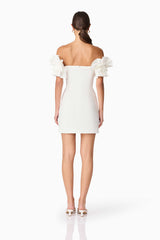 Brunette model wearing Nola Off The Shoulder Mini Dress in White back shot
