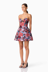 Brunette model wearing Delphine Tulip Mini Dress in Pink & Black Floral side shot