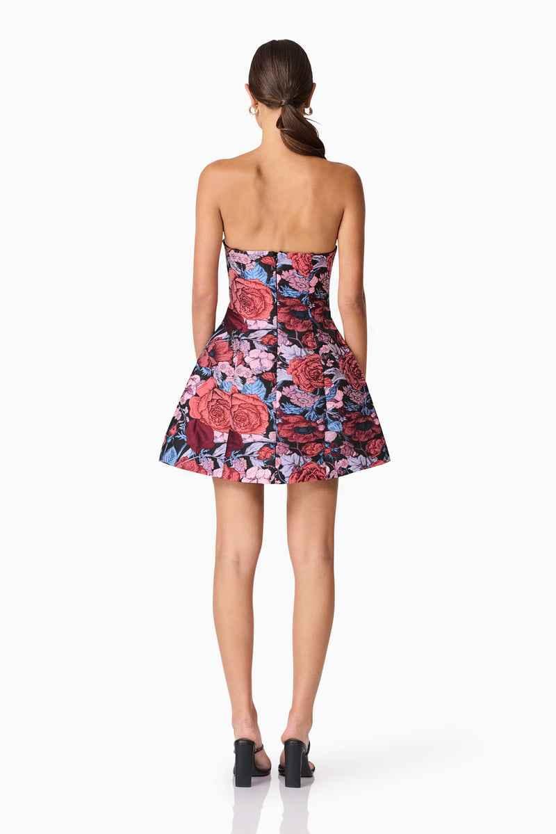 Brunette model wearing Delphine Tulip Mini Dress in Pink & Black Floral back shot