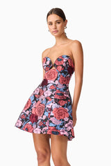 Brunette model wearing Delphine Tulip Mini Dress in Pink & Black Floral close up posed shot