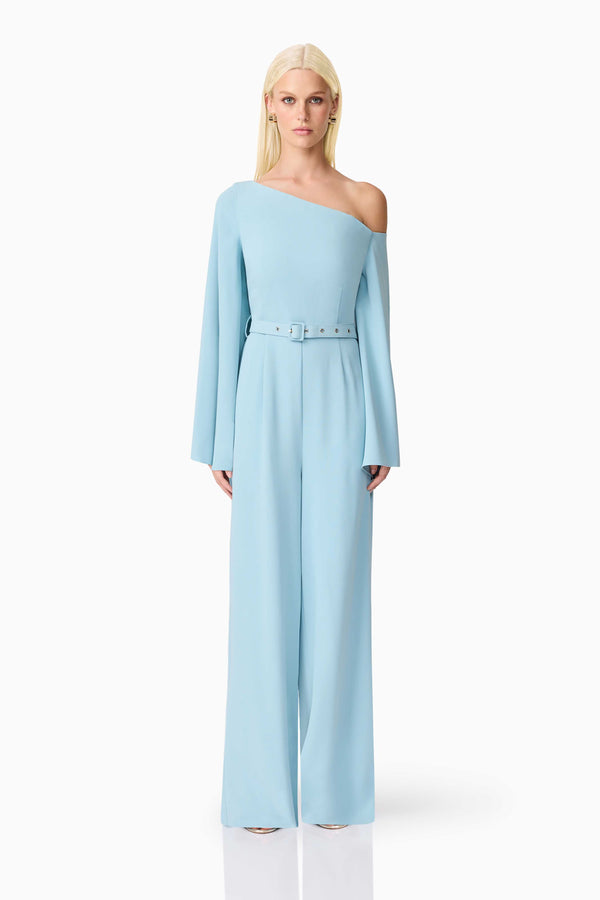 Blonde model wearing Elinor Asymmetrical Jumpsuit in Blue front shot