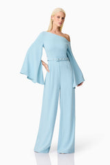 Blonde model wearing Elinor Asymmetrical Jumpsuit in Blue posed shot  with hand on hip