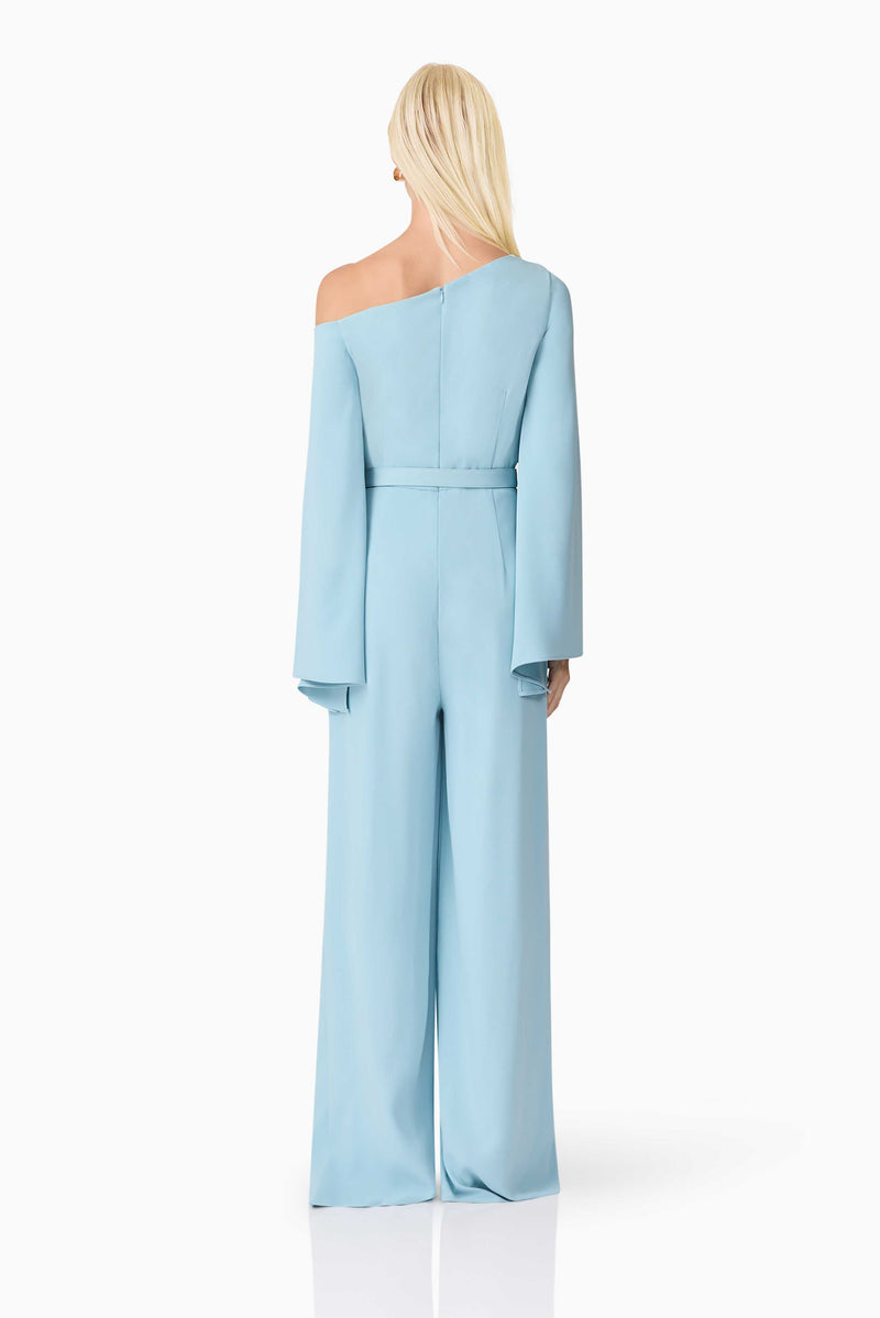 Blonde model wearing Elinor Asymmetrical Jumpsuit in Blue back shot