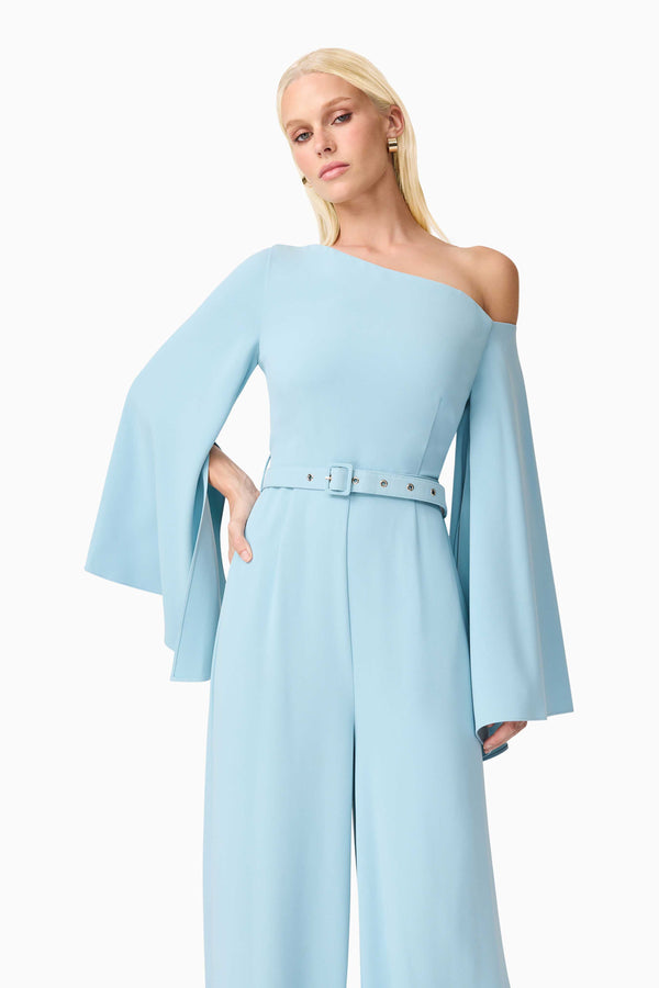 Blonde model wearing Elinor Asymmetrical Jumpsuit in Blue posed shot