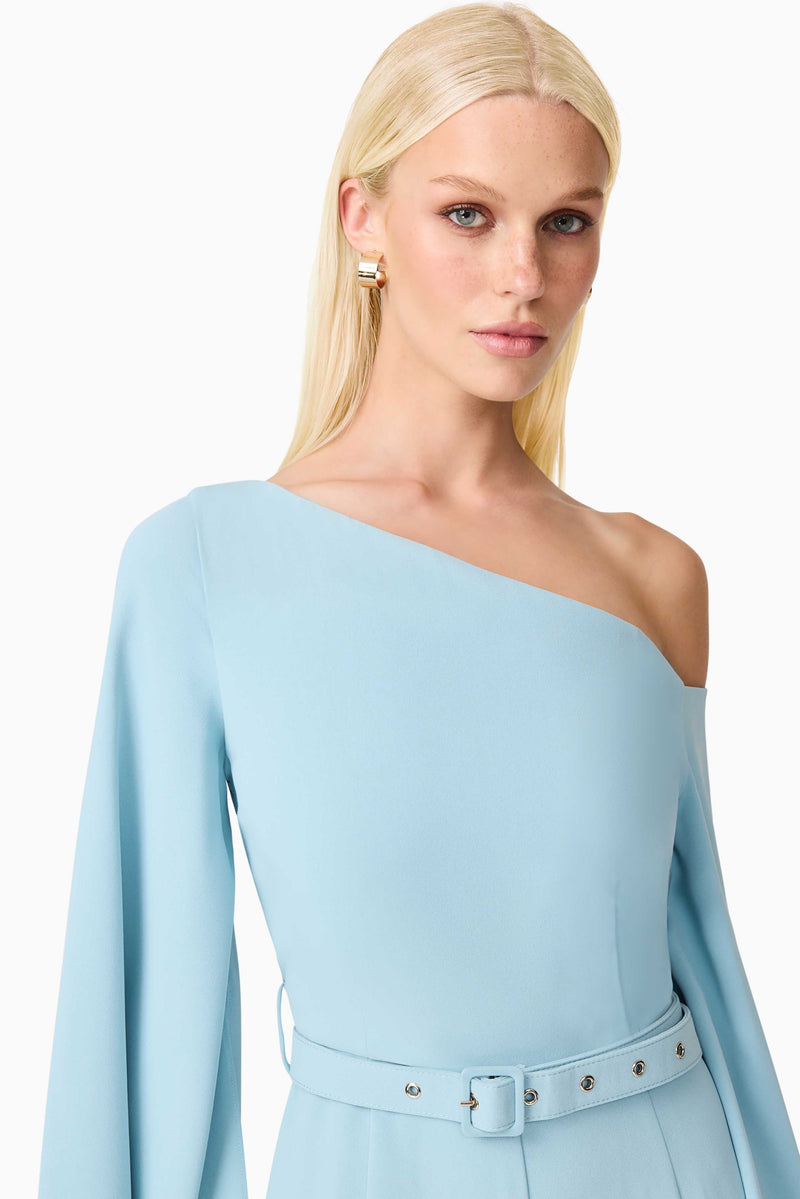 Blonde model wearing Elinor Asymmetrical Jumpsuit in Blue close up shot