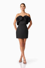 Brunette model wearing Sharon Strapless Mini Dress in Black posed hands behind hips shot 