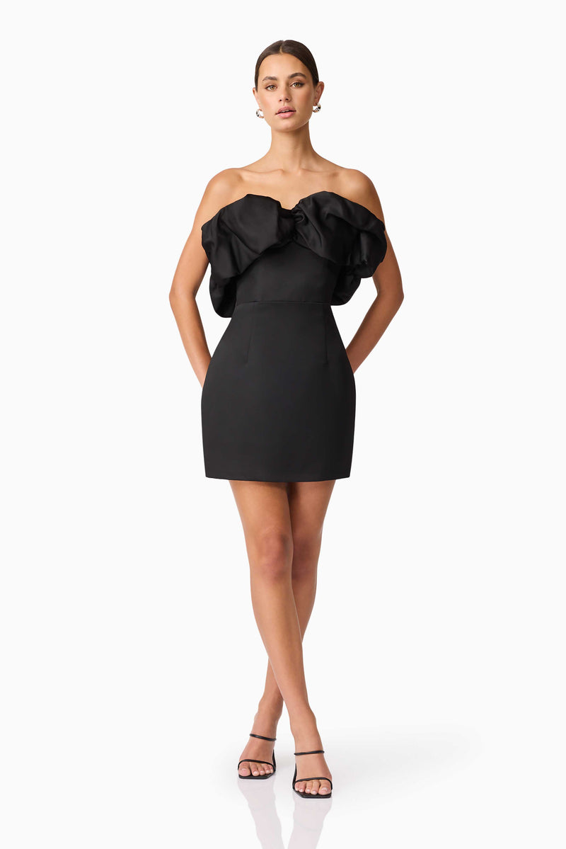 Brunette model wearing Sharon Strapless Mini Dress in Black posed hands behind hips shot 